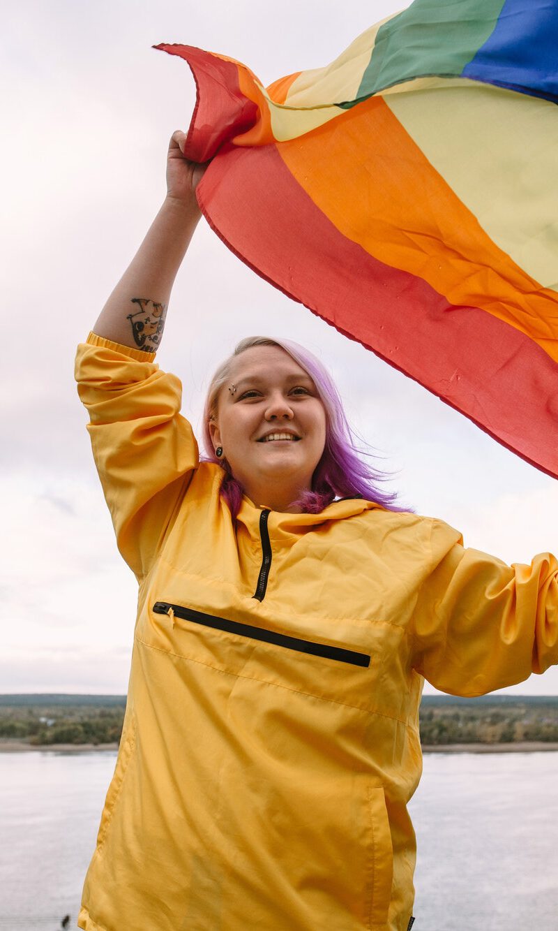 happy young woman lesbian holding lgbtq pride flag